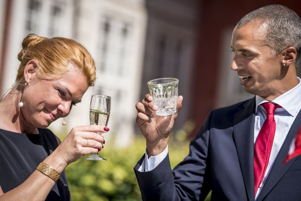 Inger Støjberg (V) og Mattias Tesfaye (S) skåler ved torsdagens overdragelsesceremoni i Udlændinge- og Integrationsministeriet. Tesfaye afviser beskyldninger fra Støjberg om løftebrud.