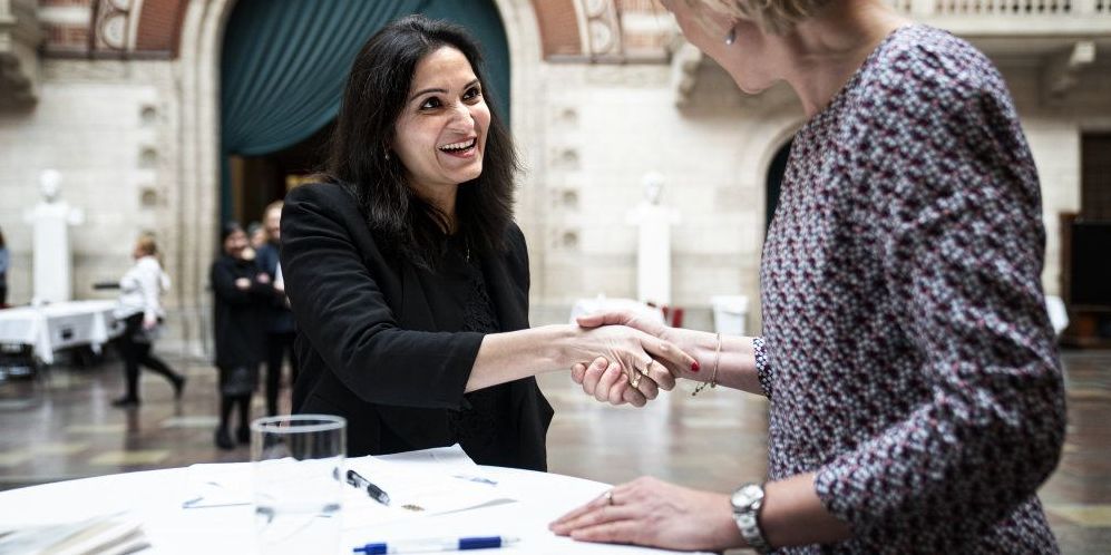 Swati Joshi underskriver erklæringen og udveksler håndtryk med Københavns Kommunes beskæftigelses- og integrationsborgmester ved en grundlovsceremoni i februar. Ceremonien er sat på pause på grund af coronavirusset.