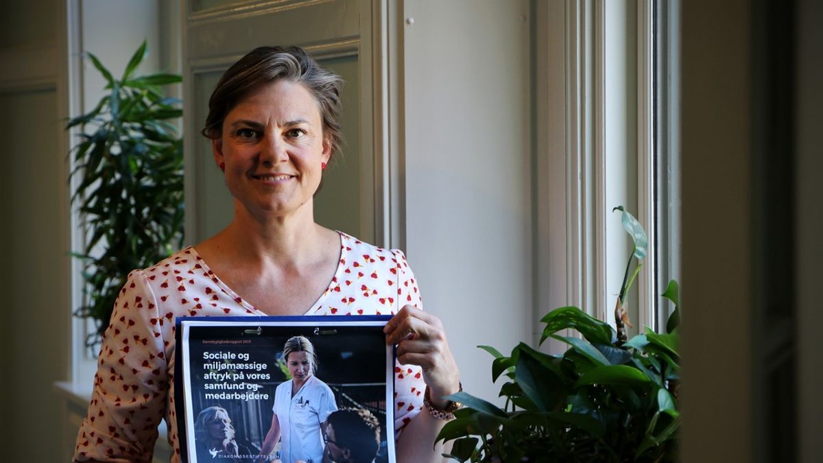 Sekretariatschef Mette Fjording med den nye bæredygtighedsrapport, som kobler Diakonissestiftelsens strategi med FN’s verdensmål.