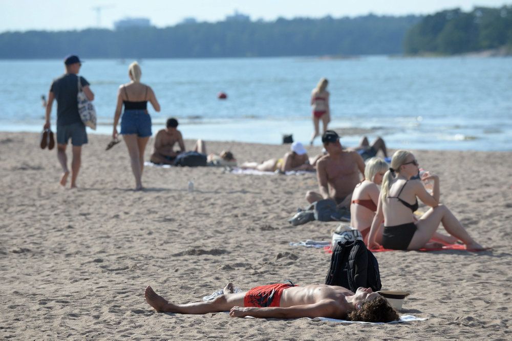Danskere skal undgå ikke-nødvendige rejser til Finland. Her nyder strandgæster solen i Helsinki. (Arkivfoto)