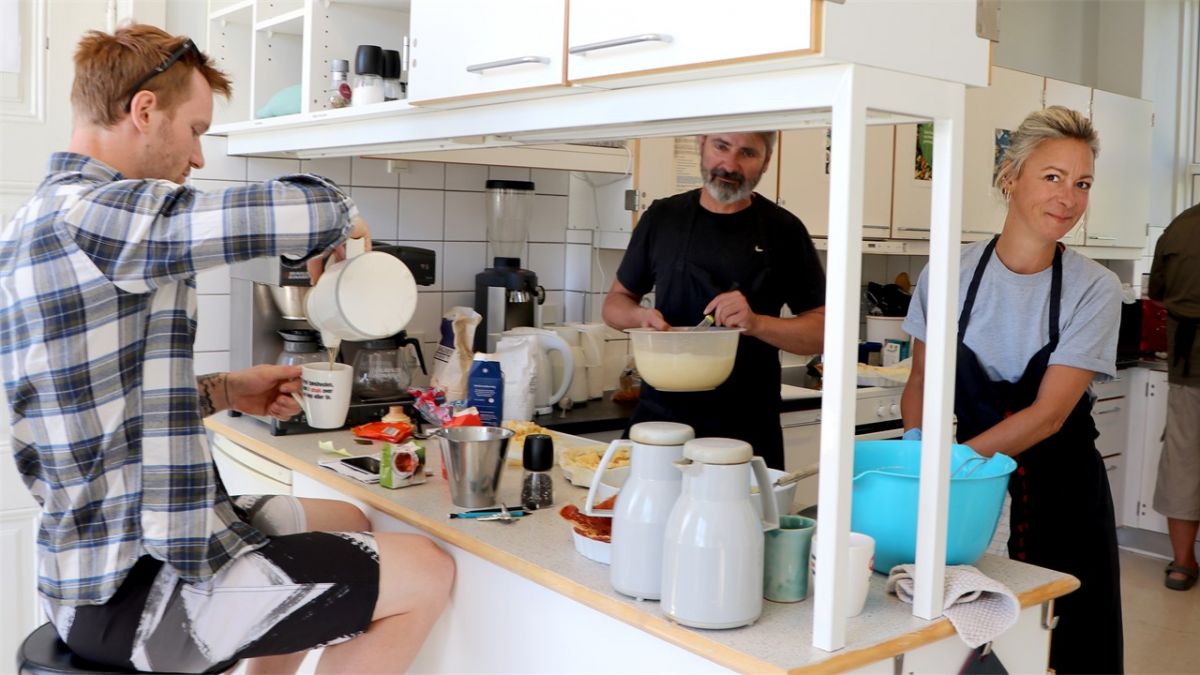 Jacob Mols (t.v.) tager en kop kaffe, mens Signe Kromann Østergaard er i køkkenet. Det falder ham helt naturligt at være i andres selskab.