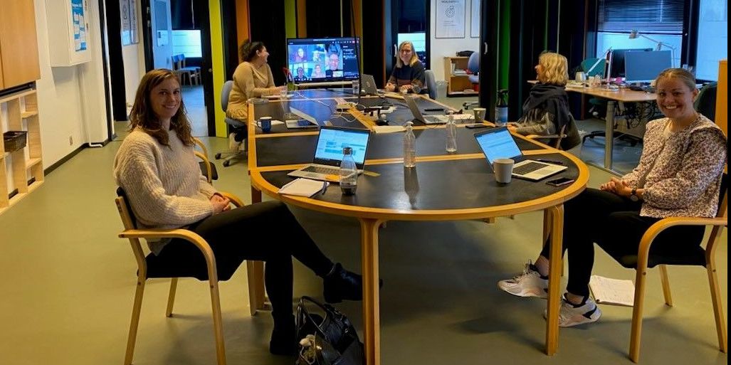 Medarbejderne i Opgang til Opgang holder møde om, hvordan tværfagligheden kan bruges konkret i familierne. Det er rundt om bordet Christina Lenon, Cand.Pæd.Psyk (forrest tv.), Saima Mushtaq, Uddannelseskonsulent (bagest tv.), Henriette Gaardbo, Foreningskonsulent (bagest th.), Tanja de Regt, Jobkonsulent (midten th.) og Jane Jensen, Familierådgiver (forrest th.)
På skærmen med hjemmefra er Malene Post, Virksomhedskonsulent, Lene Madsen, Familierådgiver, Trine Krogh, Sundhedskonsulent, Mette Bødskov, Pædagog og Hani Balahang, Socialrådgiver Socialpsykiatri og udsatte voksne.