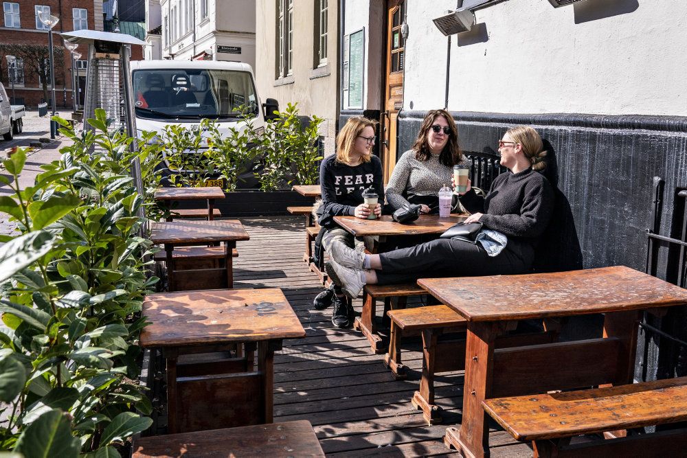 Forårssolen nydes udenfor, her takeaway kaffe på CW Obels Plads i Aalborg.