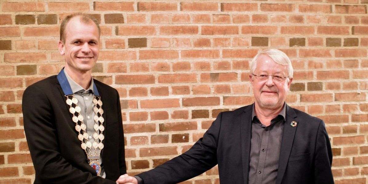 Kasper Juncher Bjerregård fra Venstre (t.v.) i Norddjurs Kommune fik på det konstituerende byrådsmøde overdraget borgmesterkæden fra socialdemokraten Jan Petersen.