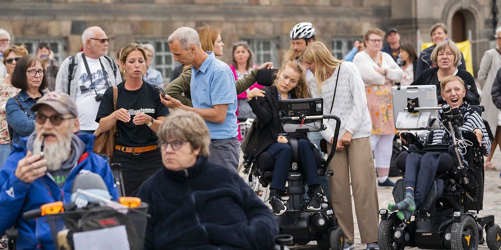 Oven på økonomiaftalen i foråret 2021 var handicaporganisationer på pletten til store demonstrationer foran Christiansborg i juni 2021. Iver Houmark Andersen (i blå t-shirt), som er redaktør på NB-Kommune, var på pletten for at interviewe de vrede og frustrerede borgere.