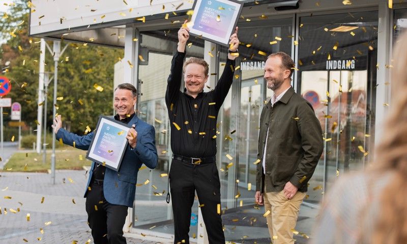 Borgmester Carsten Rasmussen (S) (yderst til venstre) jubler sammen med (i midten) direktør i Arena Næstved, Jakob Brixvold, og (til højre) programansvarlig i DR, Erik Struve Hansen, tirsdag morgen over, at Næstved har fået MGP-værtsskab i 2023.