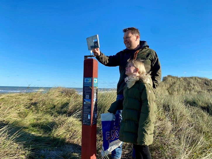 Formand for Teknik- og Miljøudvalget Søren Homann afprøver den nye fotostation. Mobiltelefonen placeres i holderen, inden man tager sit foto.